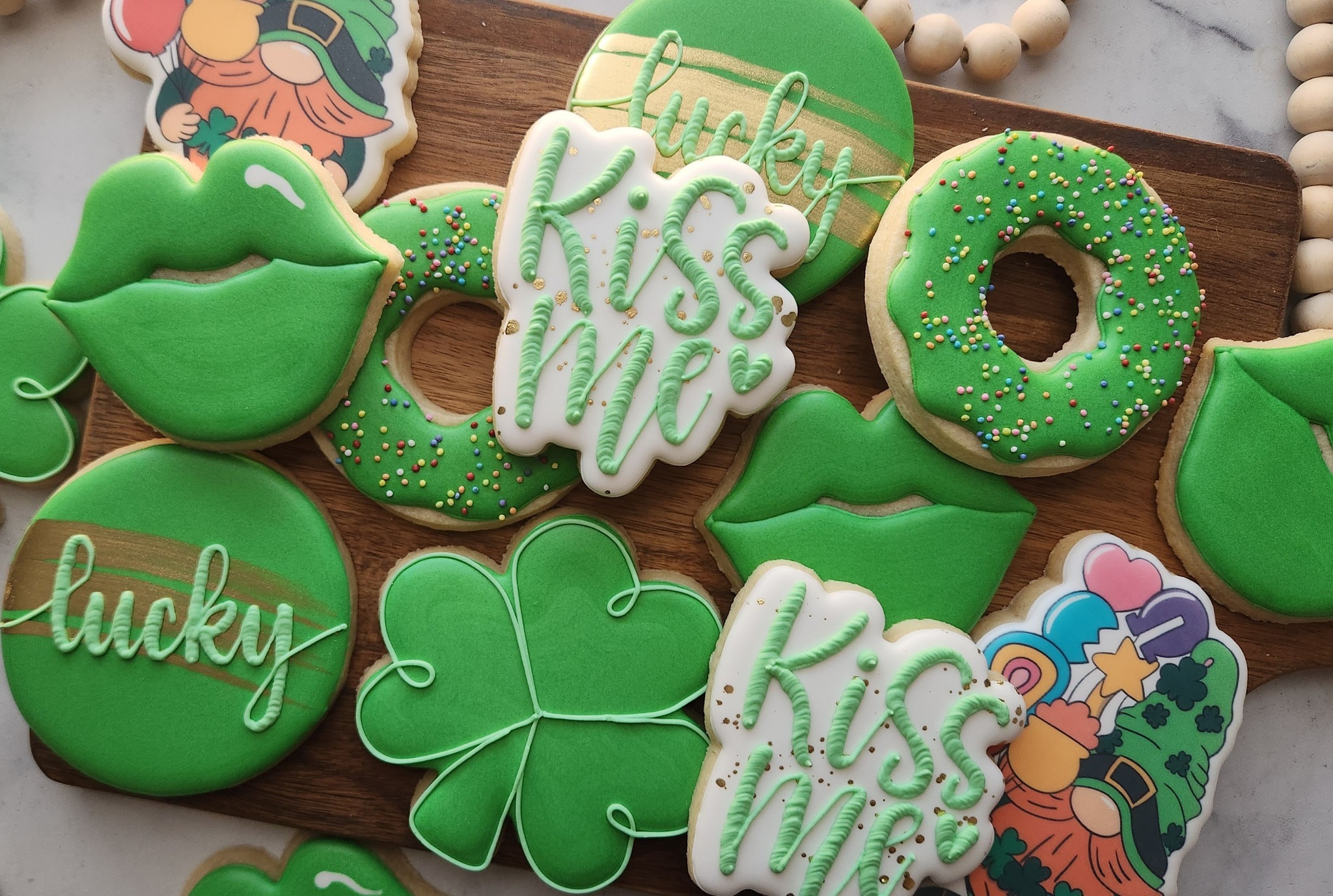 Green St. Patrick’s Day cookies with clovers, lips, donuts, and lucky kiss me lettering