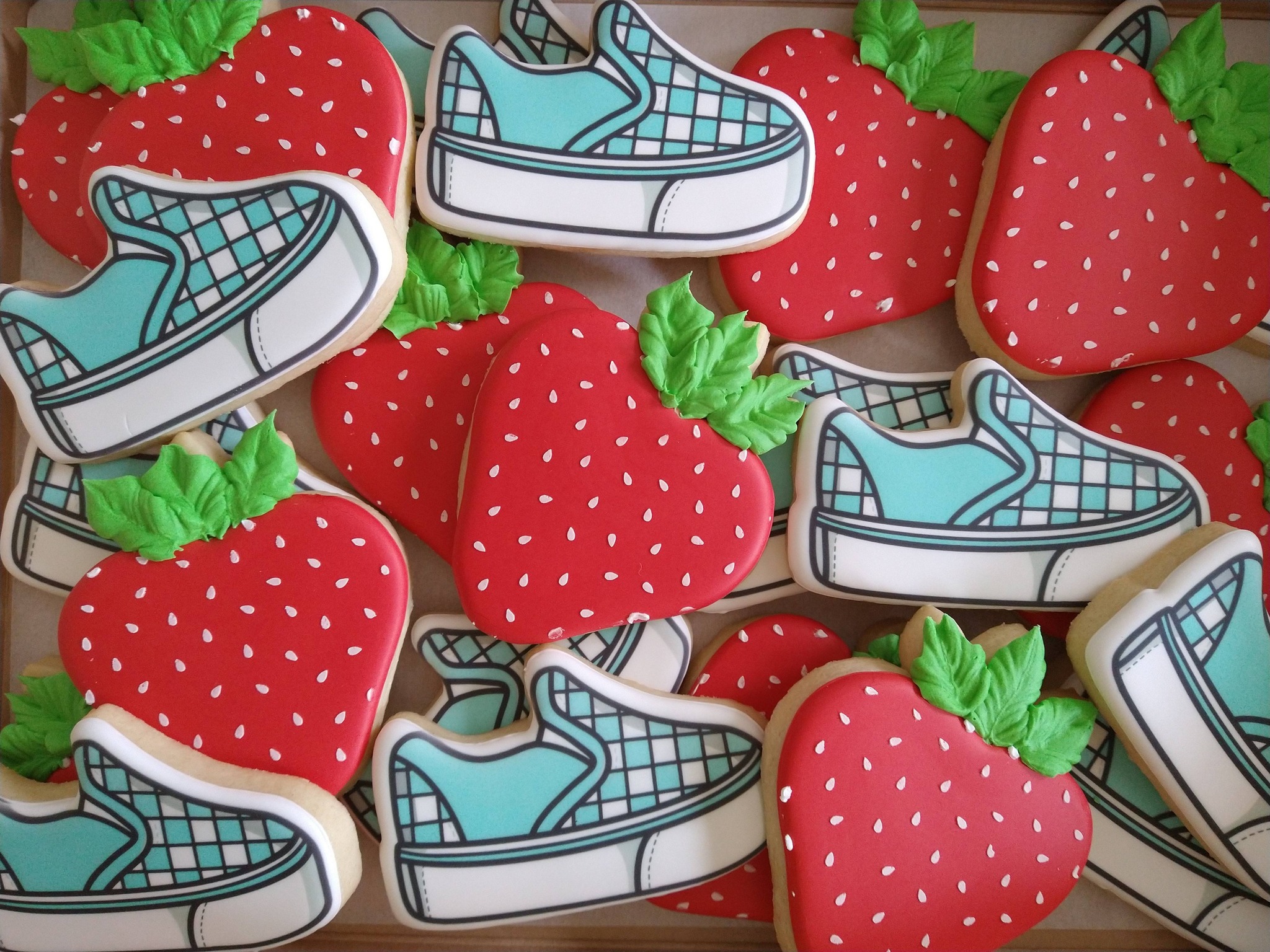 Strawberry and teal shoe cookies with bright red berry cookies and custom sneaker designs